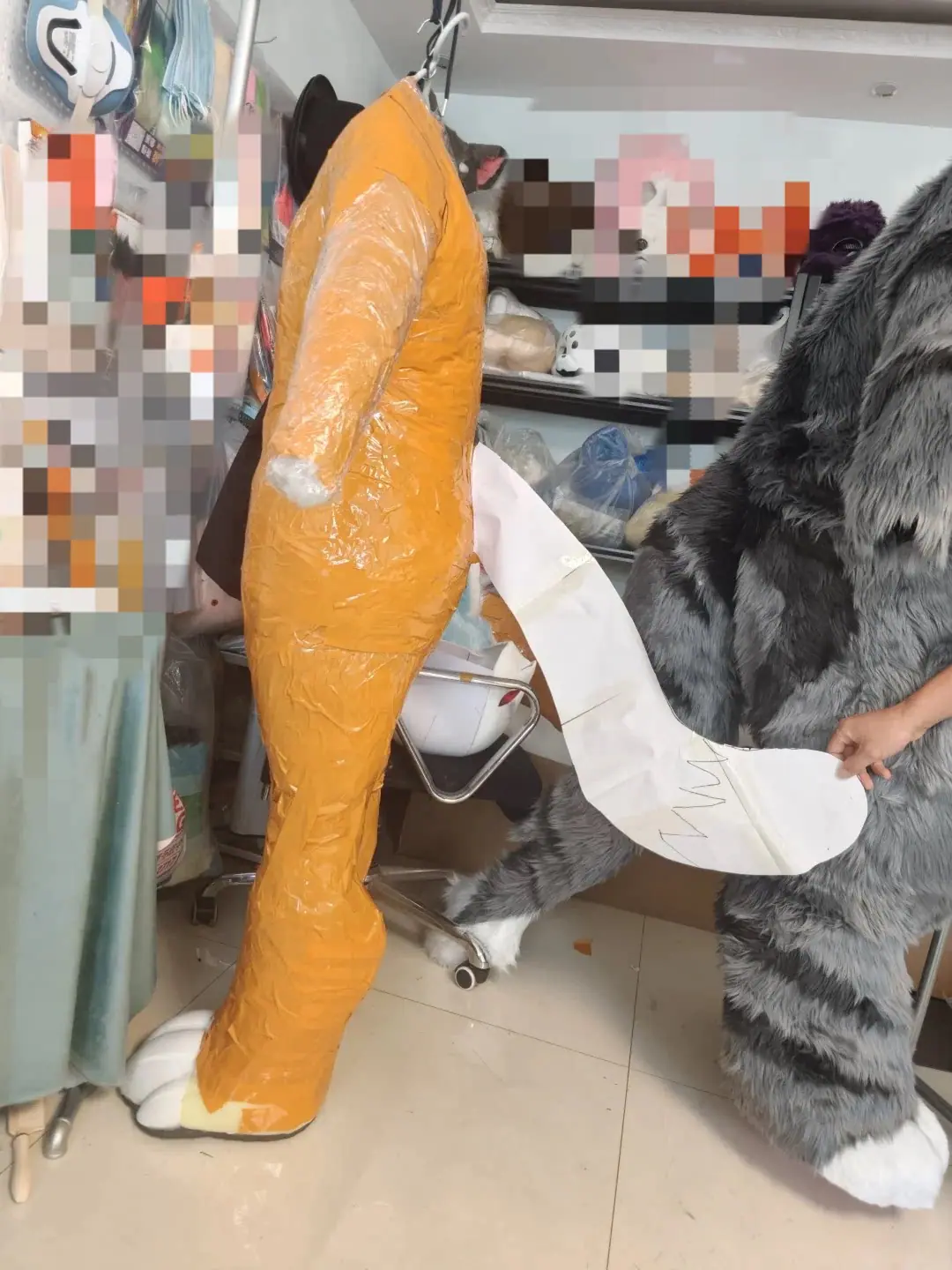 Duct-tape dummy for a custom fursuit bodysuit, with the paper tail pattern