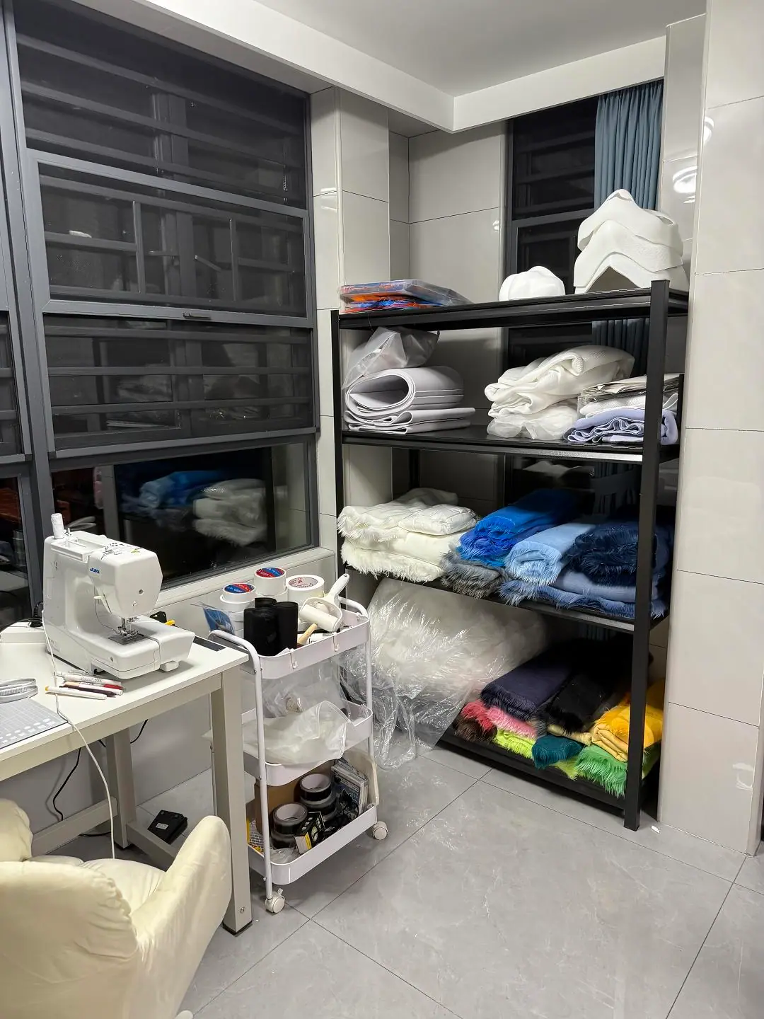 Our fursuit workshop, with sewing machines and shelves of faux fur
