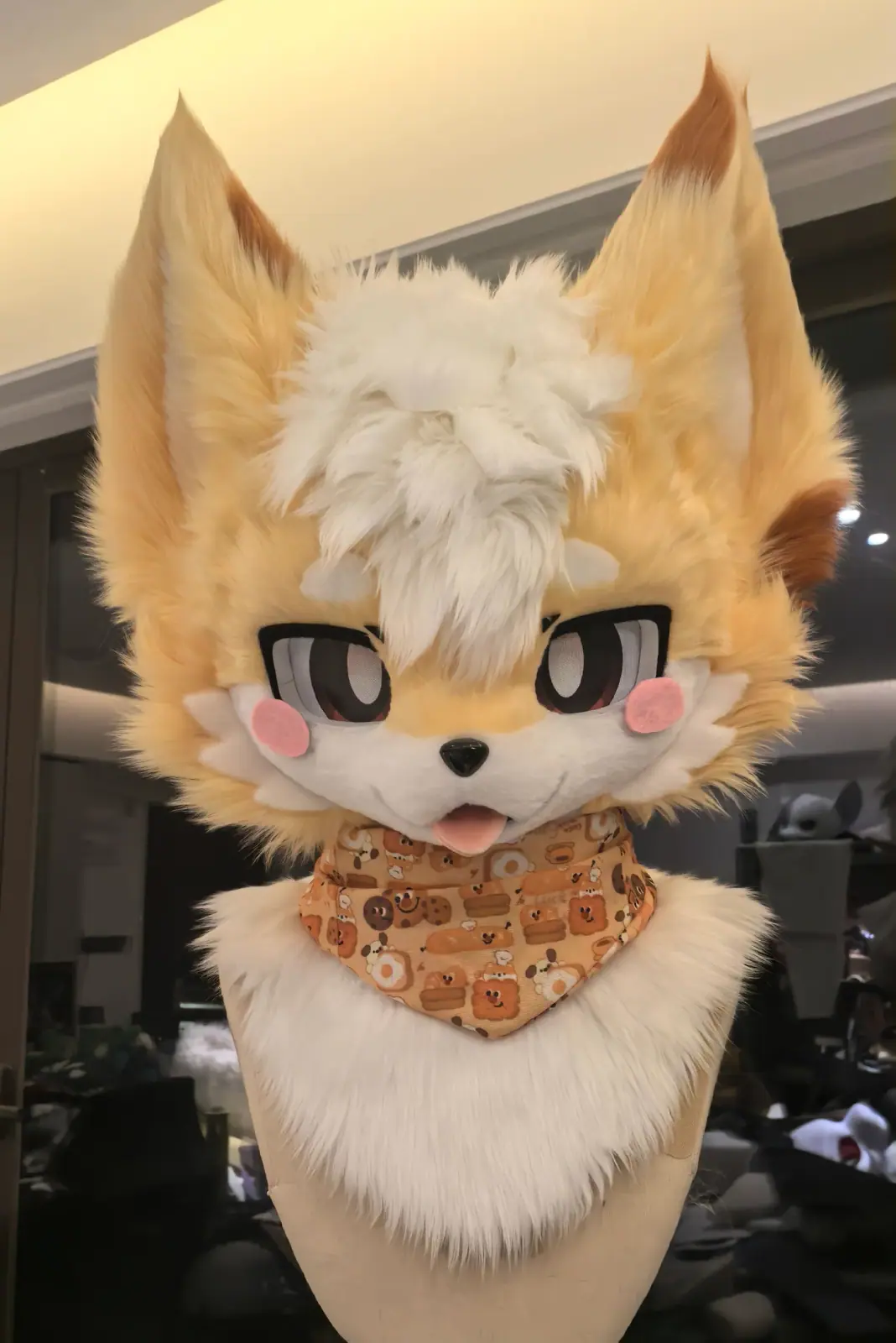 Kemono-style cream and white fox fursuit head with pink blush cheeks and a patterned bandana, front view