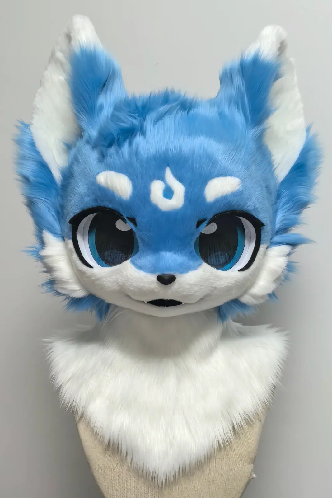 Kemono-style sky-blue and white cat fursuit head with a white forehead marking and large blue anime eyes, front view