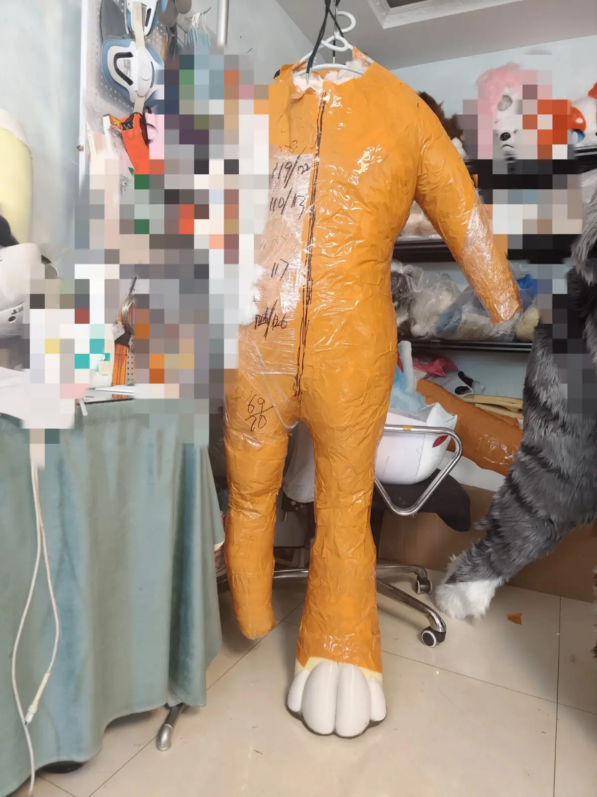 Duct-tape dummy for a custom fursuit bodysuit, with a feet paw base
