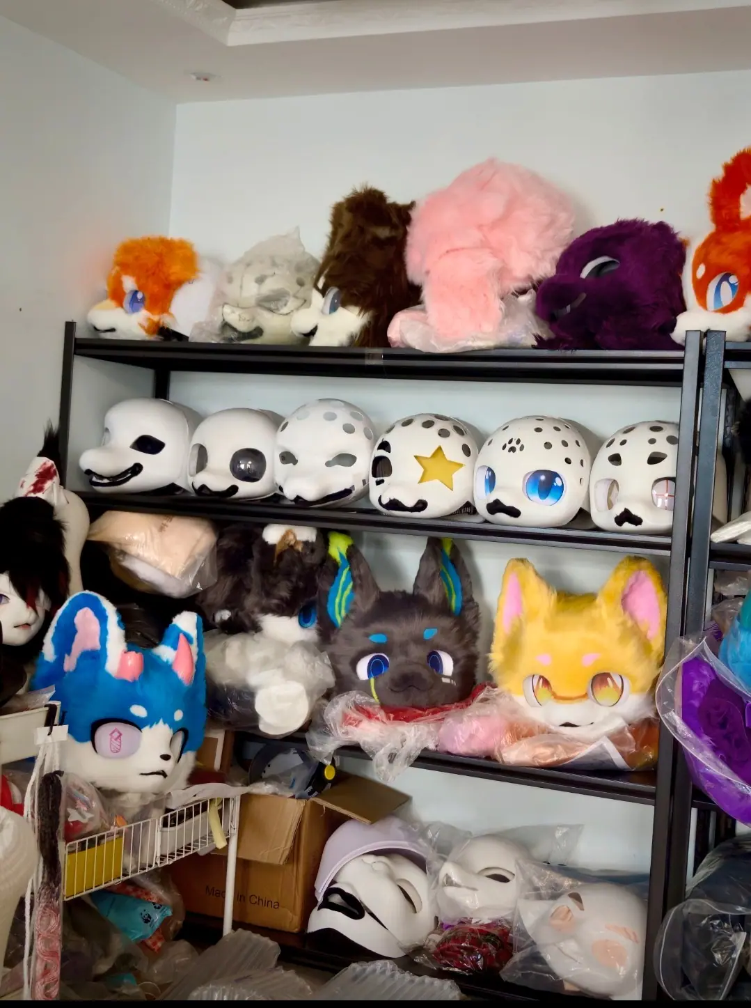 Our fursuit studio, with finished heads and 3D-printed head bases on the shelves